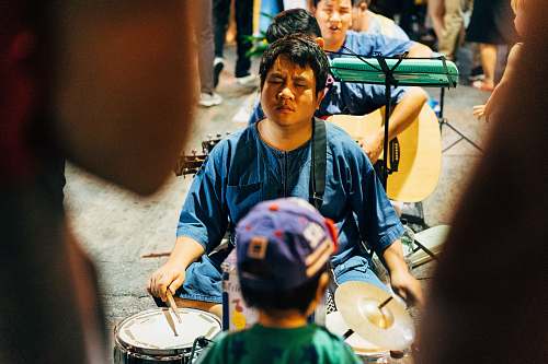 musical instrument boy in blue and green crew neck shirt playing drum musician